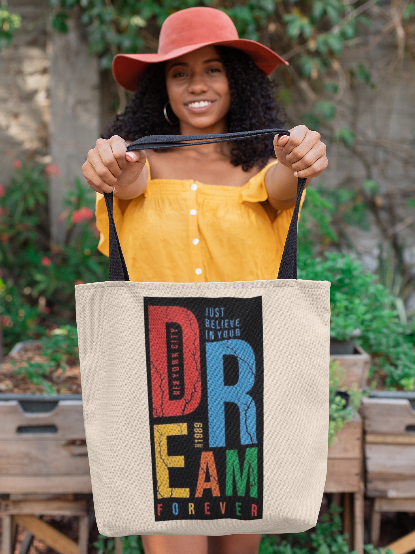 Woman holding a tote bag with colorful text design outdoors