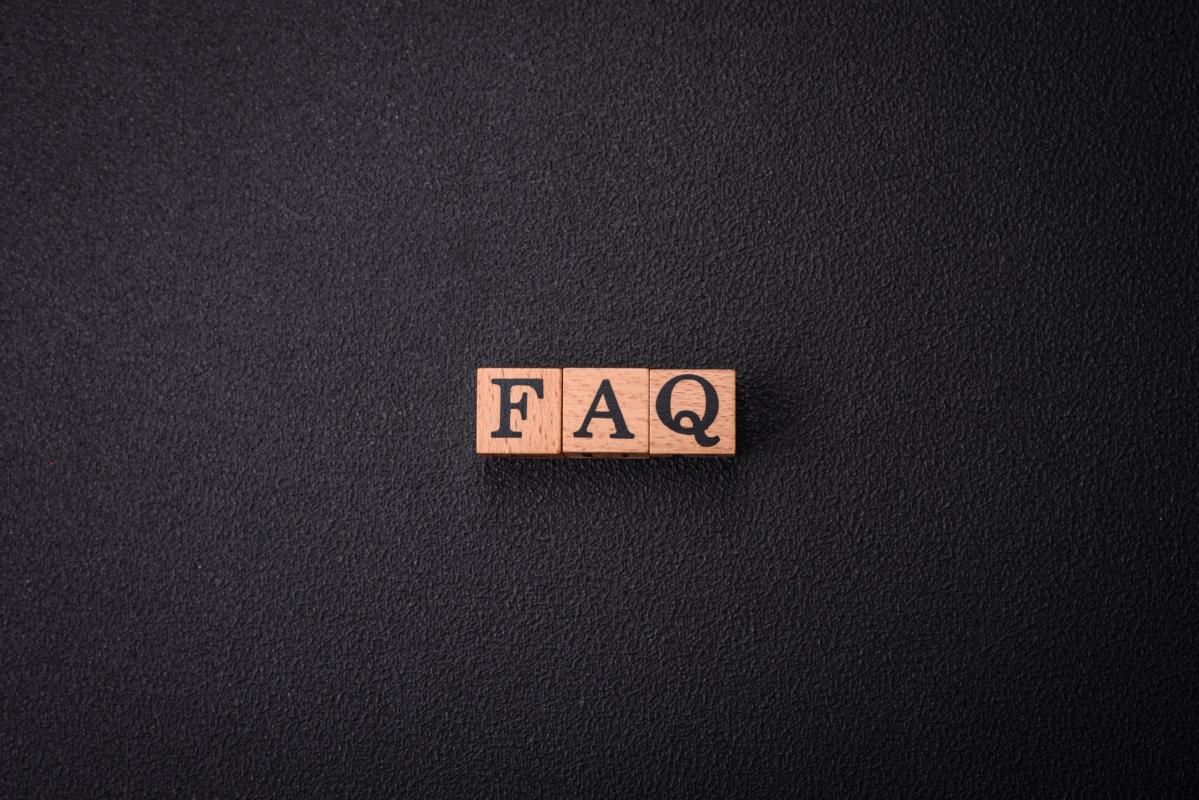 Wooden blocks with 'FAQ' letters on a black background
