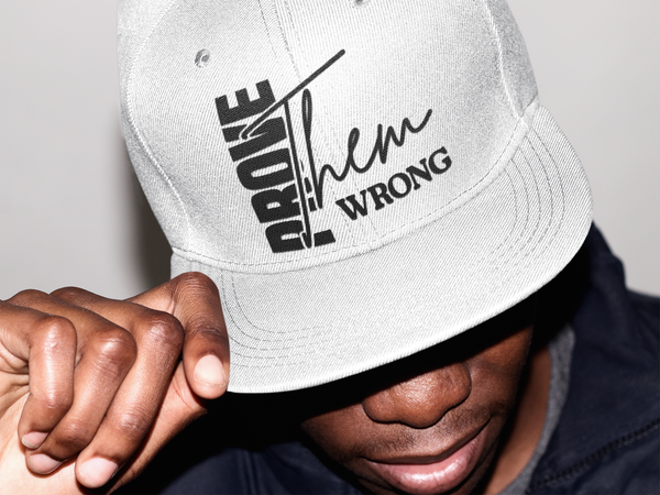 Person wearing a white cap with text, against a neutral background