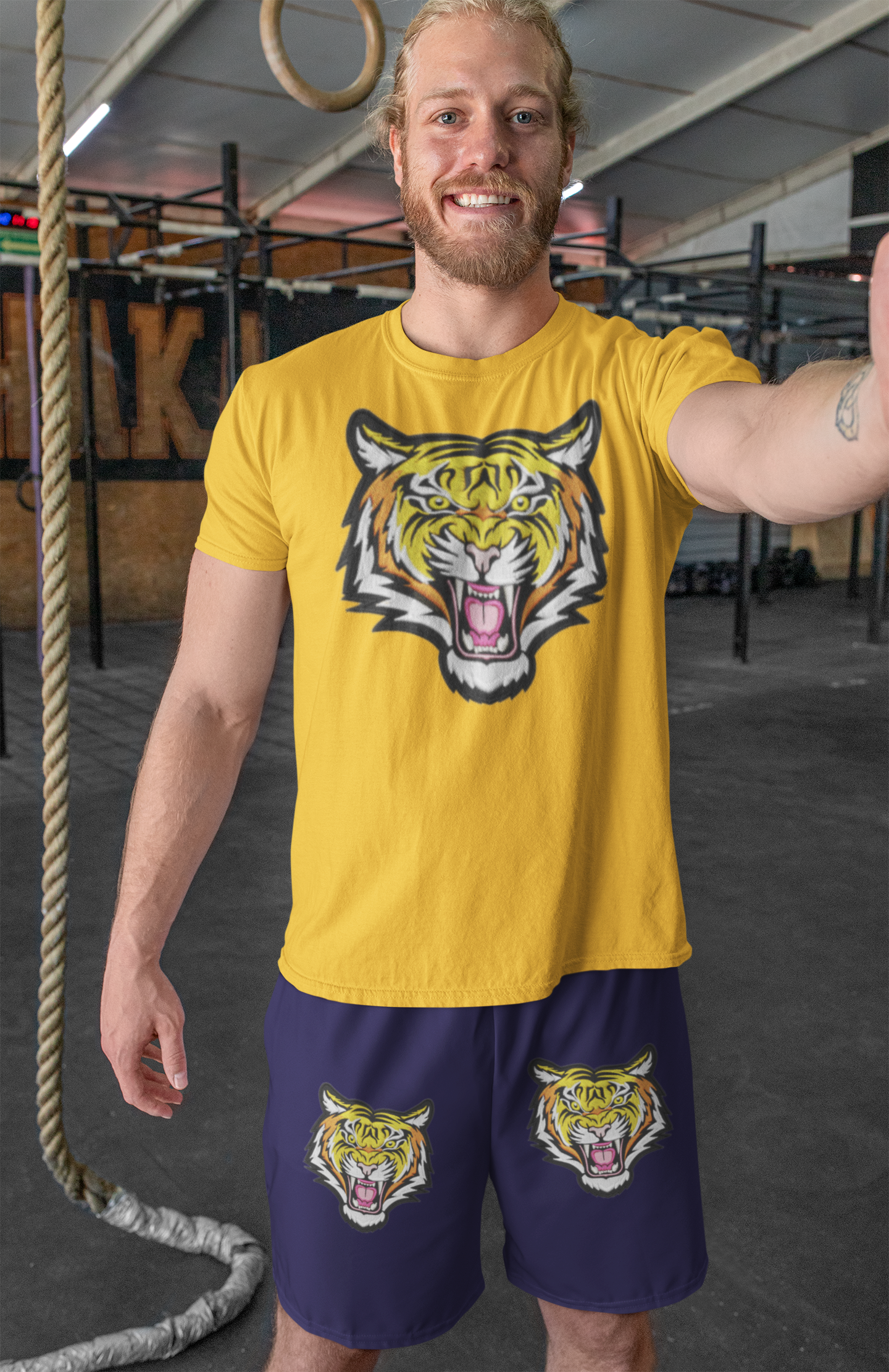 Man wearing a yellow t-shirt with a tiger design in a gym setting