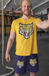 Man wearing a yellow t-shirt with a tiger design in a gym setting
